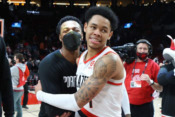 Jan 3, 2022; Portland, Oregon, USA; Portland Trail Blazers guard Anfernee Simons (1) celebrates with teammate Trail Blazers' guard Dennis Smith Jr. (10) after scoring 43 points in Portland's 136-131 win over Atlanta Hawks at Moda Center.